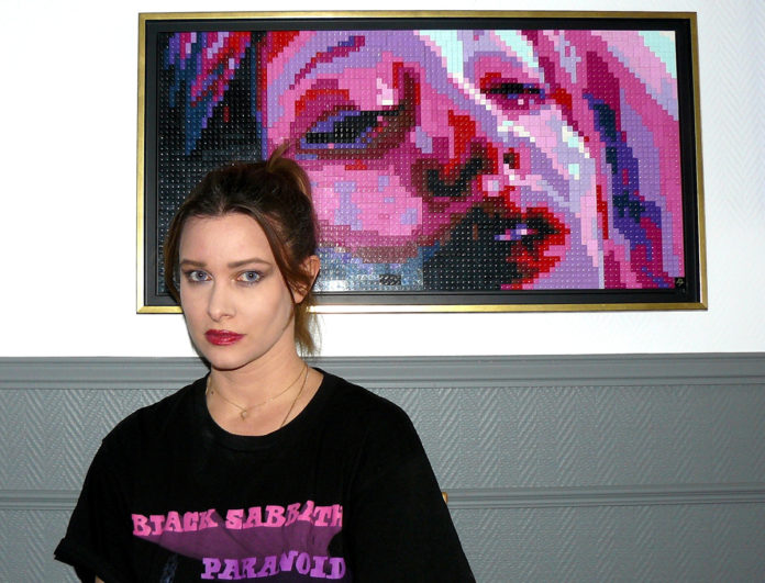 image of artist Pauline in front of her work