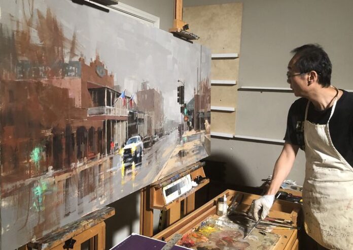 Qiang Huang working on a large-scale painting in his studio