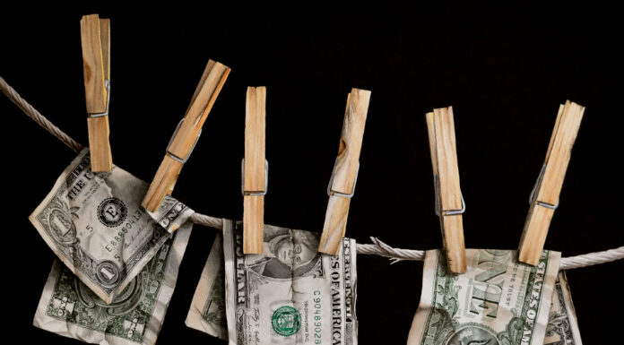 Money, Money, Money Lynn Pratt, "Money Laundering," watercolor, 21 x 15 in.; painting of money hanging from clothespins